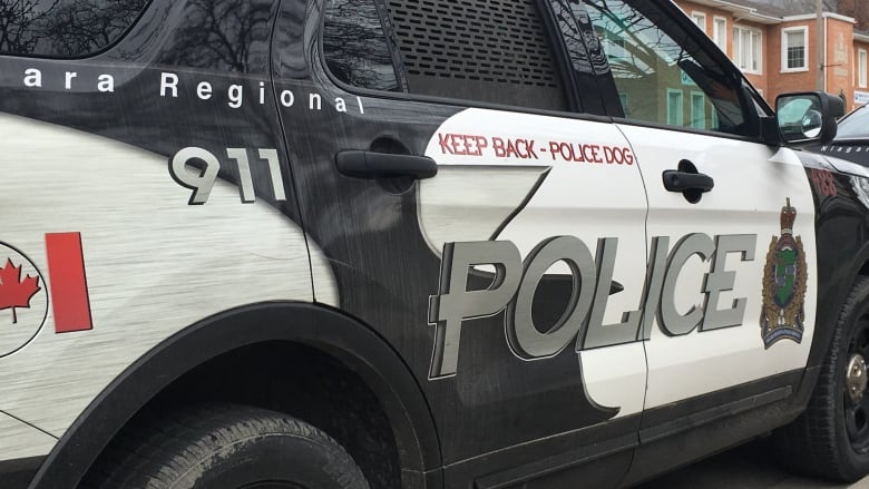 A close-up photo shows the side of an SUV with police markings. 