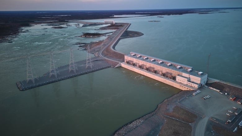 An aerial view of a hydro-electric dam, spillway and reservoir.