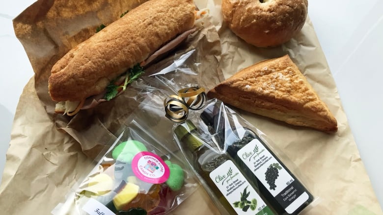 Fresh baked bread, a bag of candy and a bag of olive oil and balsamic vinegar.