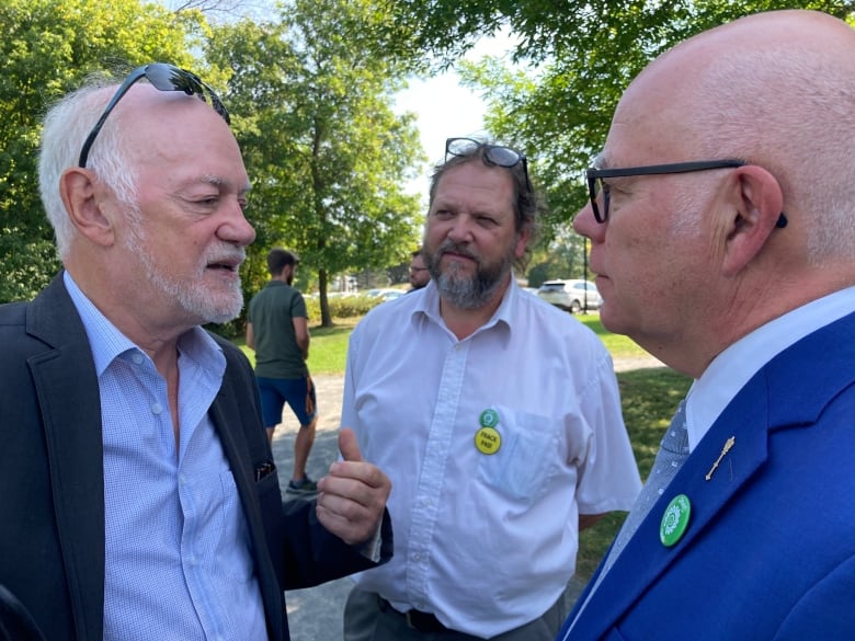 Three men standing and talking