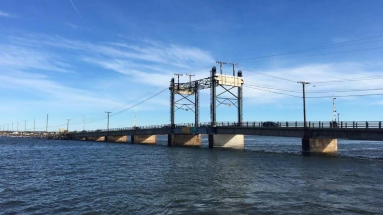 A bridge with power lines running above it. 