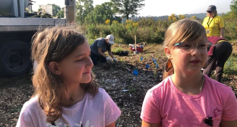 Two young girls standing in a garden 