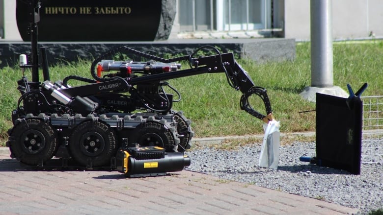 A bomb disposal robot inspects a suspicious package.