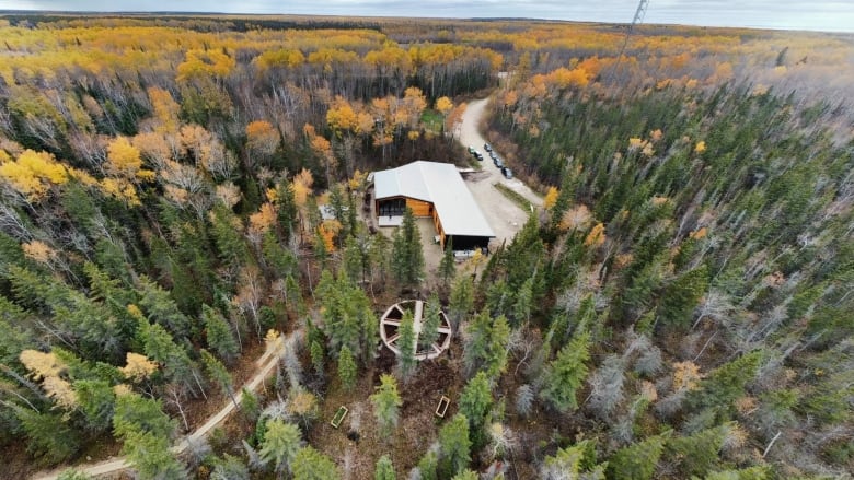 A drone shot of a lakeside retreat surrounded by forest.