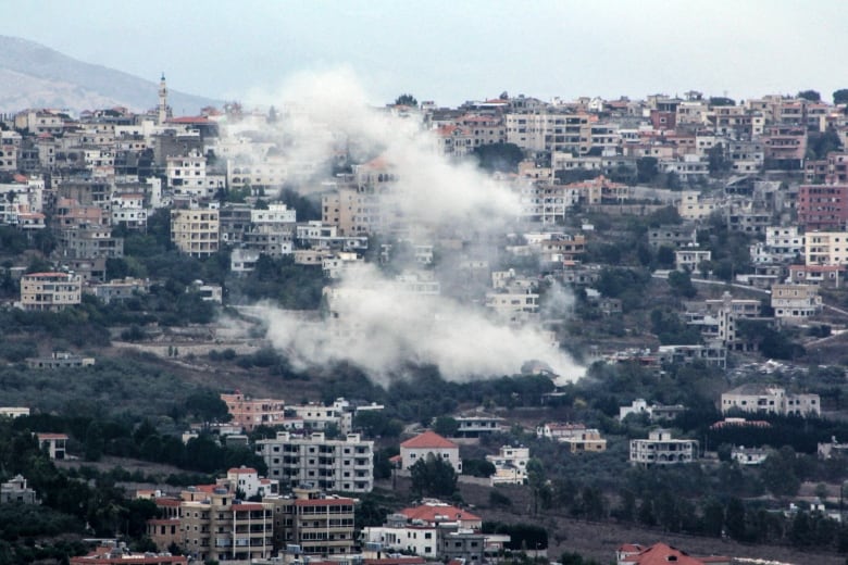 Smoke billows from a cluster of buildings.