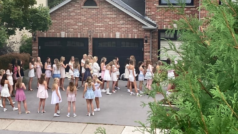 Dozens of women wait for instructions as they arrive and leave by the busload at 167 Sunnyside Drive, a home that's being rented out as a short-term rental. 