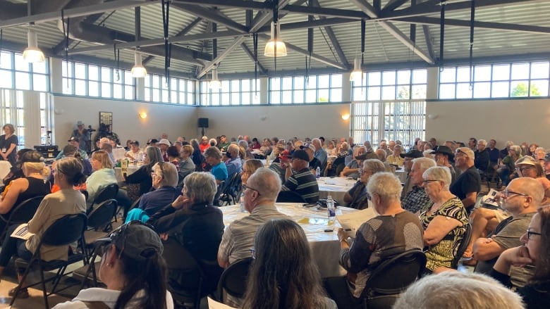 A room full of people sitting around tables.