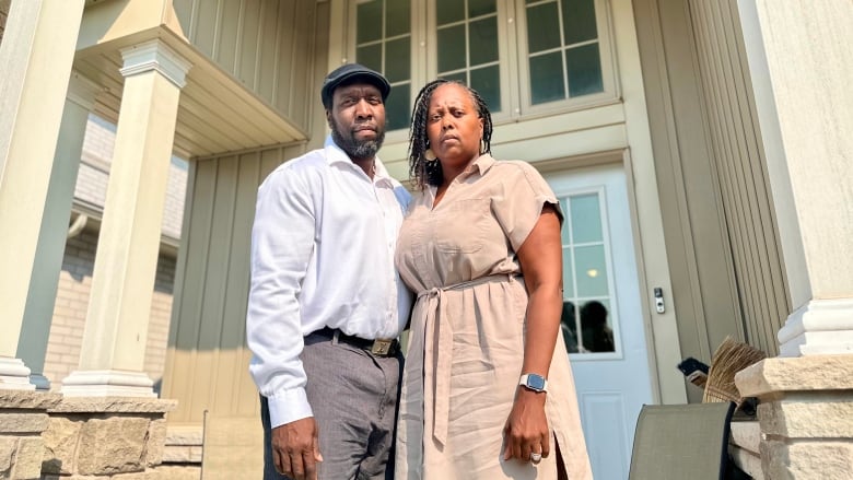 couple stands on front porch