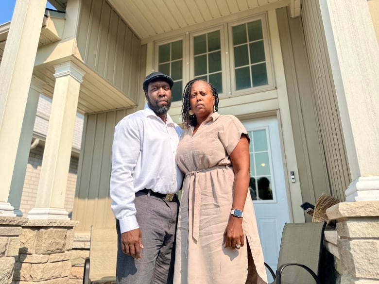 couple stands on front porch