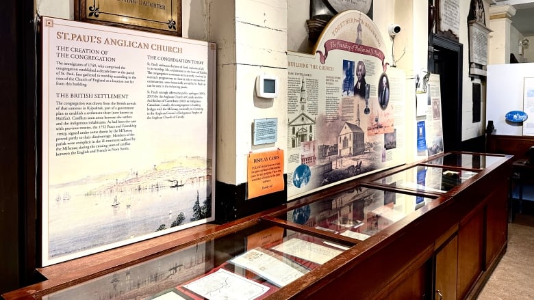 Placards are posted telling the history of a church above a wood cabinet.