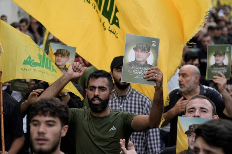 Hezbollah supporters carry pictures of Hezbollah commander Ibrahim Akil, during his funeral procession in Beirut's southern suburb, Sunday, Sept. 22, 2024. 