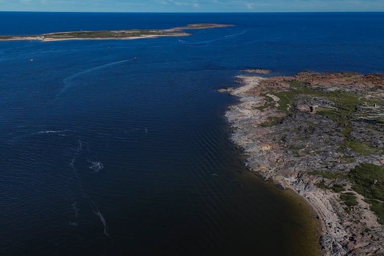 An aerial shot shows a body of open water.