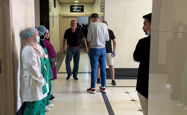 People stand outside a morgue at a hospital.