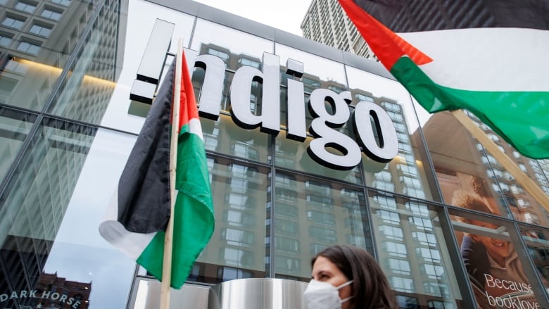 Photo of palestinian flags being flown outside an Indigo store downtown