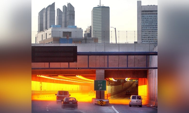 Cars drive into a tunnel.