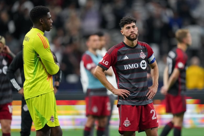 A group of soccer players look dejected.