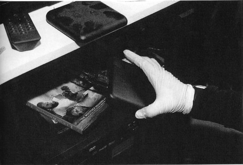 A gloved hand holds a device. 