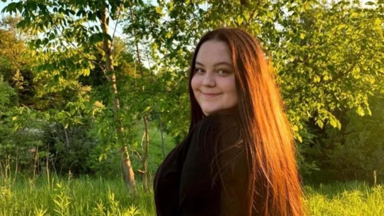 A young woman smiles at the camera.