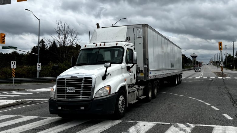 A transport truck is seen driving through a Bolton, Ont. intersection 