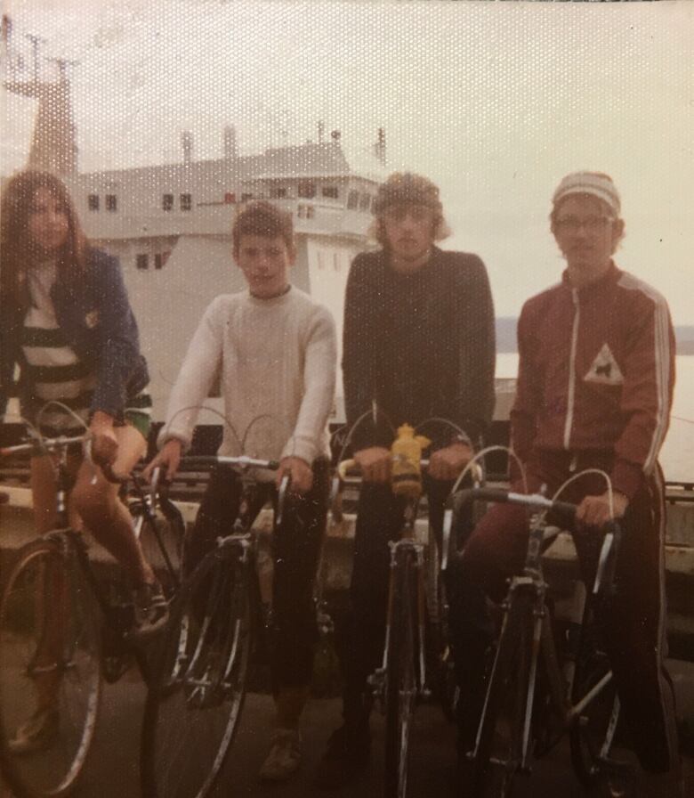 A faded photo of four people on bikes.