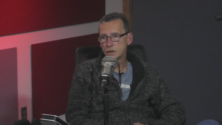 A man sitting in front of a microphone.