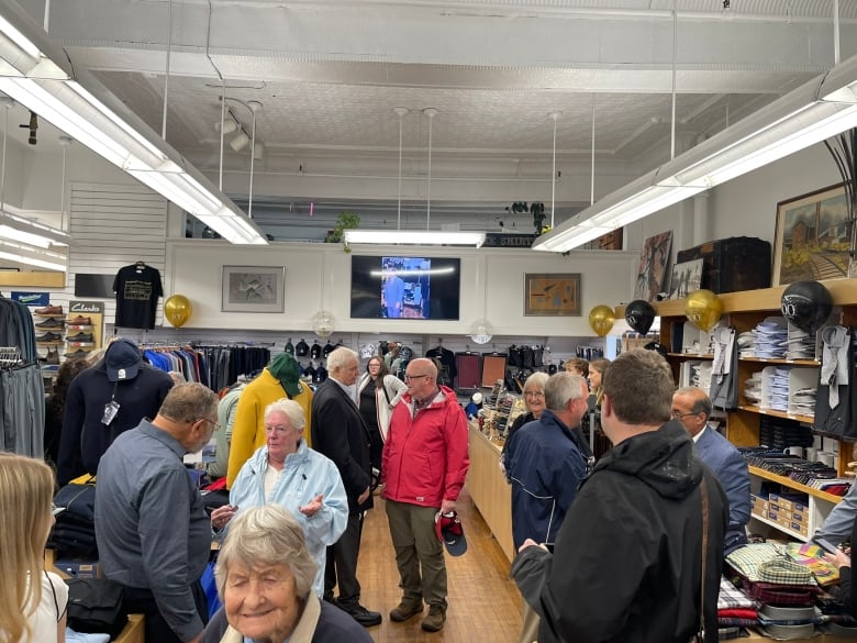 Shoppers mill about inside a store. 