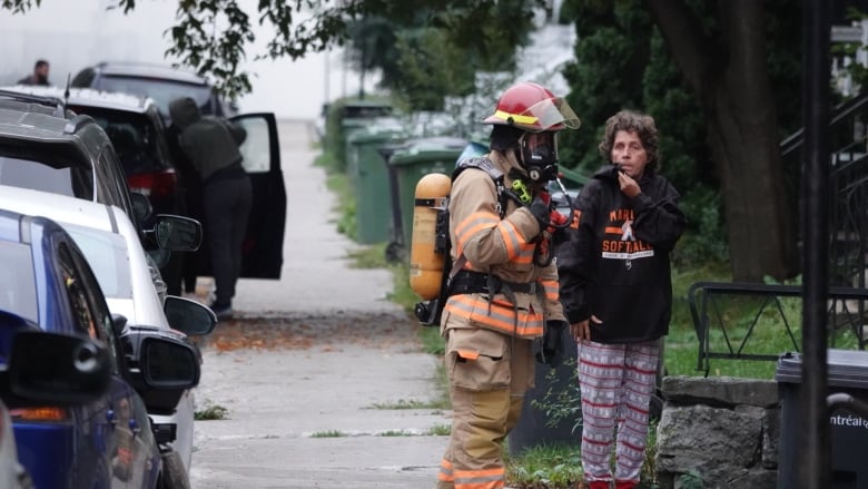 Firefighter speaks with woman on street