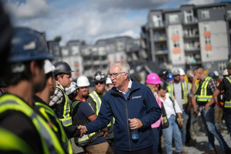 Conservative Leader John Rustad greets construction workers during a campaign stop at a condo construction site, in Surrey, B.C.