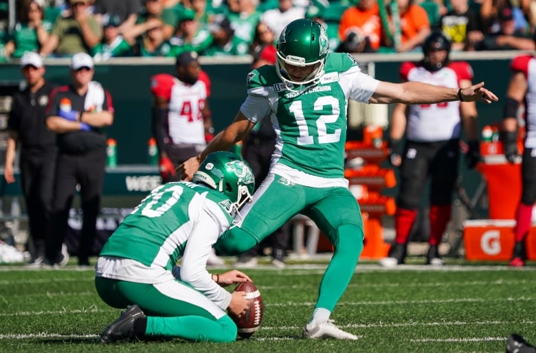 Brett Lauther kicks a football