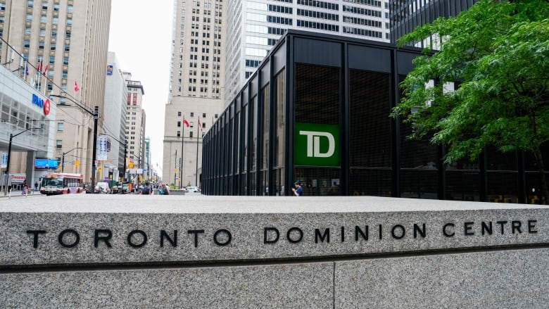 The words 'Toronto Dominion Centre' are engraved into a wall surrounded by tall office buildings.