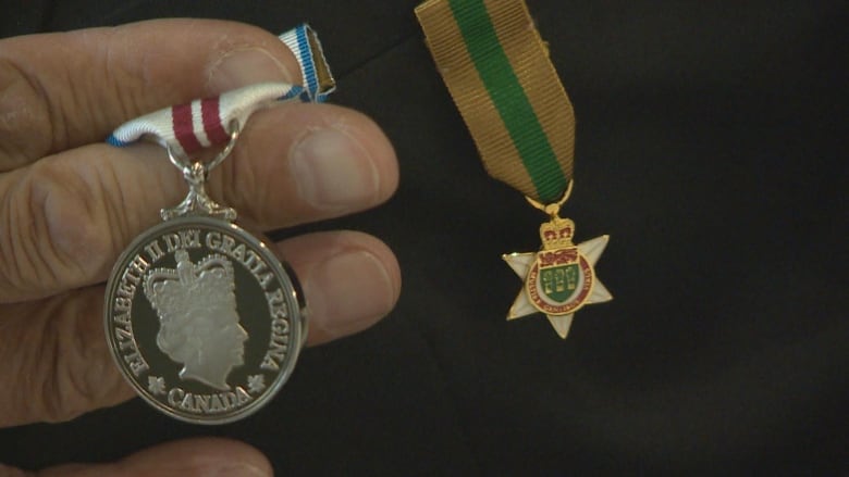 Man holding lapel pins. 