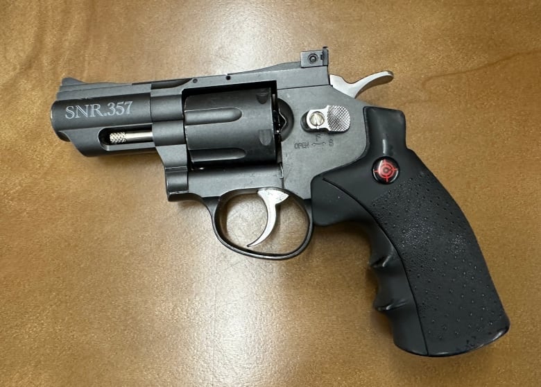 A revolver with a black handle and 