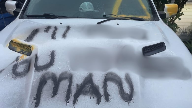 A truck with censored text spray-painted on.