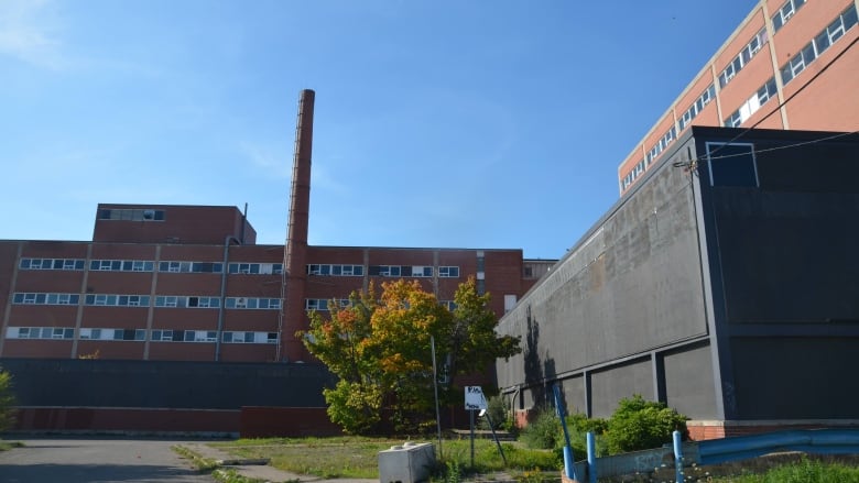 Two brick buildings including one with a large chimney.