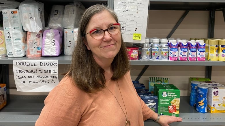 A woman standing next to shelves with food on it