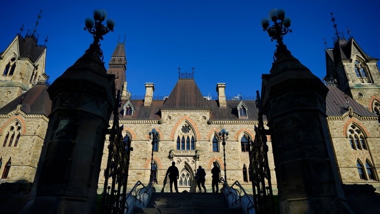 Security personnel stand in front of the West Block on Parliament Hill.