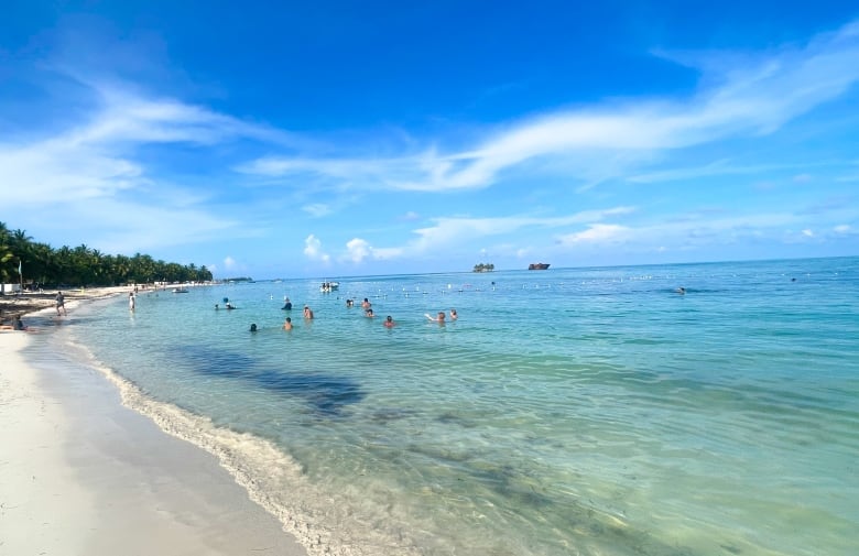 People swim in the Caribbean waters on the island of San Andres. 