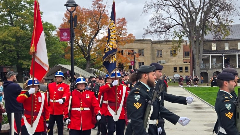 Soldiers march with a Canadian flag and the new Royal New Brunswick Regiment flag around Officers' Square. 