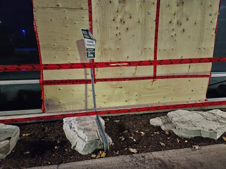 A bent parking sign leans in front of boarded up windows at the back of the CAS building in Windsor, Ont.