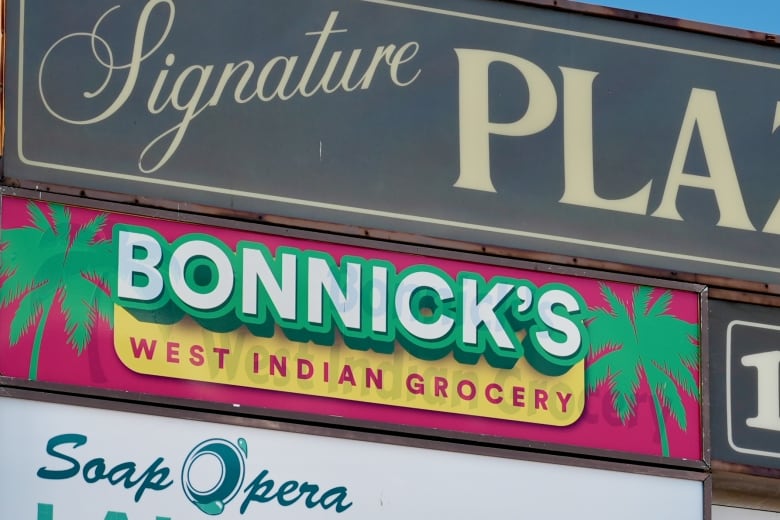 A plaza sign with various shop names.