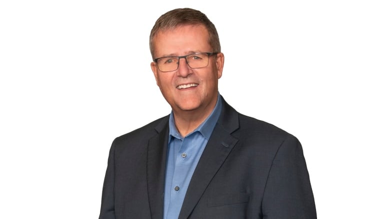 A portrait of a man in a suit against a white background