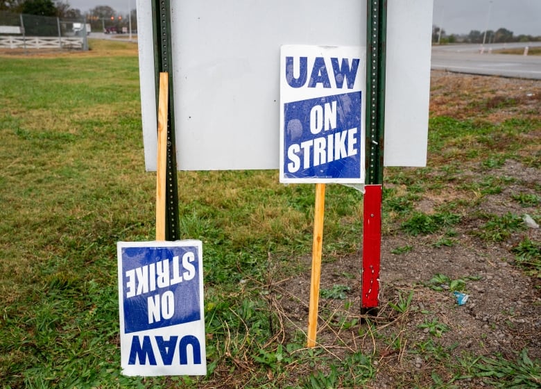 UAW strike signs shown. 