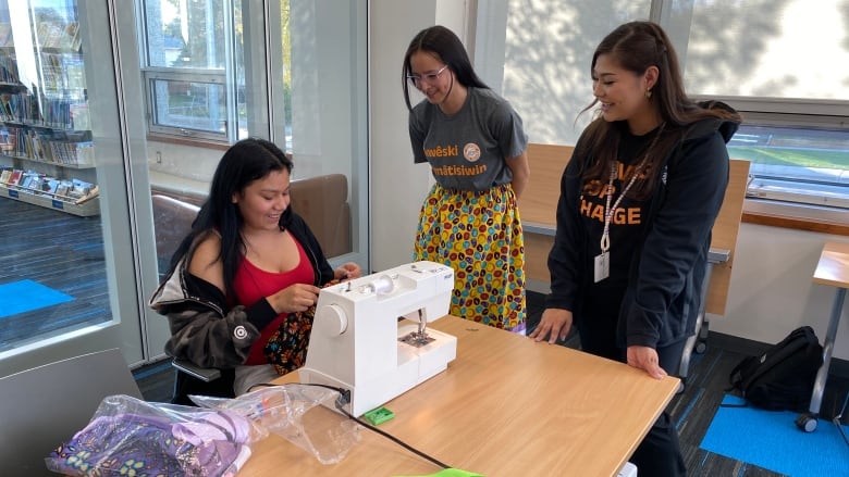 Young women learning how to sew