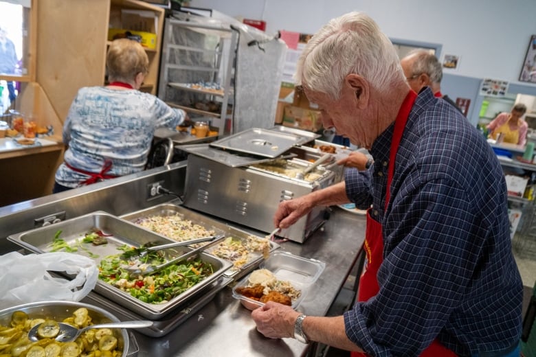 People are seen preparing food in a kitchen setting.