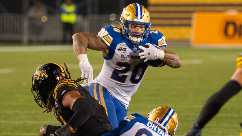 A football player runs with the football.