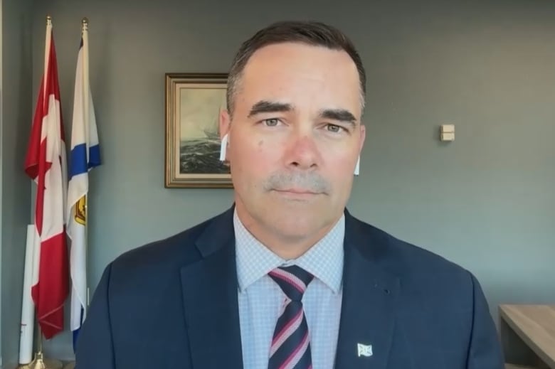 A man in a suit and tie stands in an office.