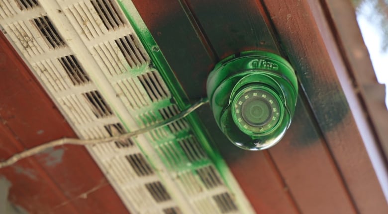 A security camera spray painted green