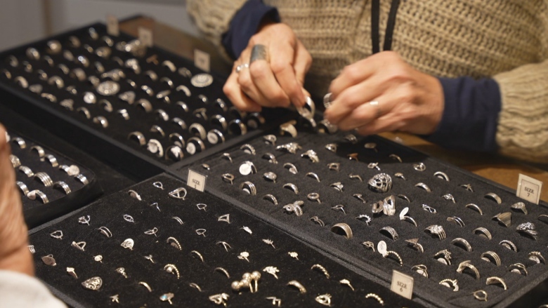 A woman's hands touch a tray of rings