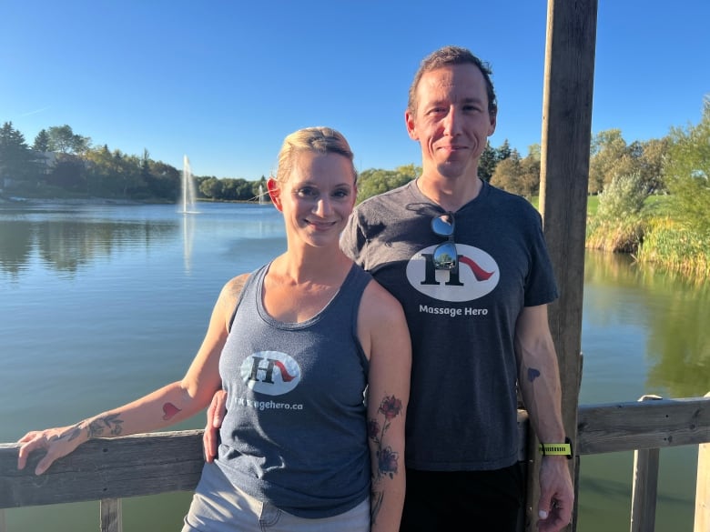 Woman and man stand by a pond