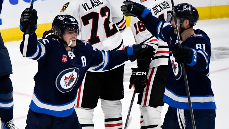 Hockey players in blue celebrate while players in white look dejected.